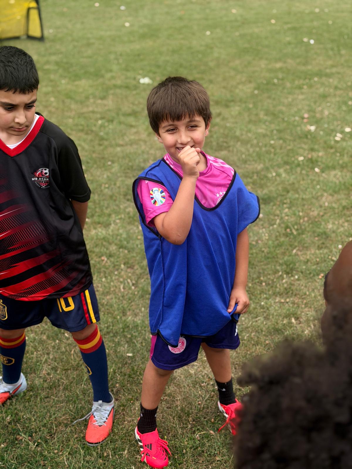 N10 Academy coach speaking with young players on the pitch
