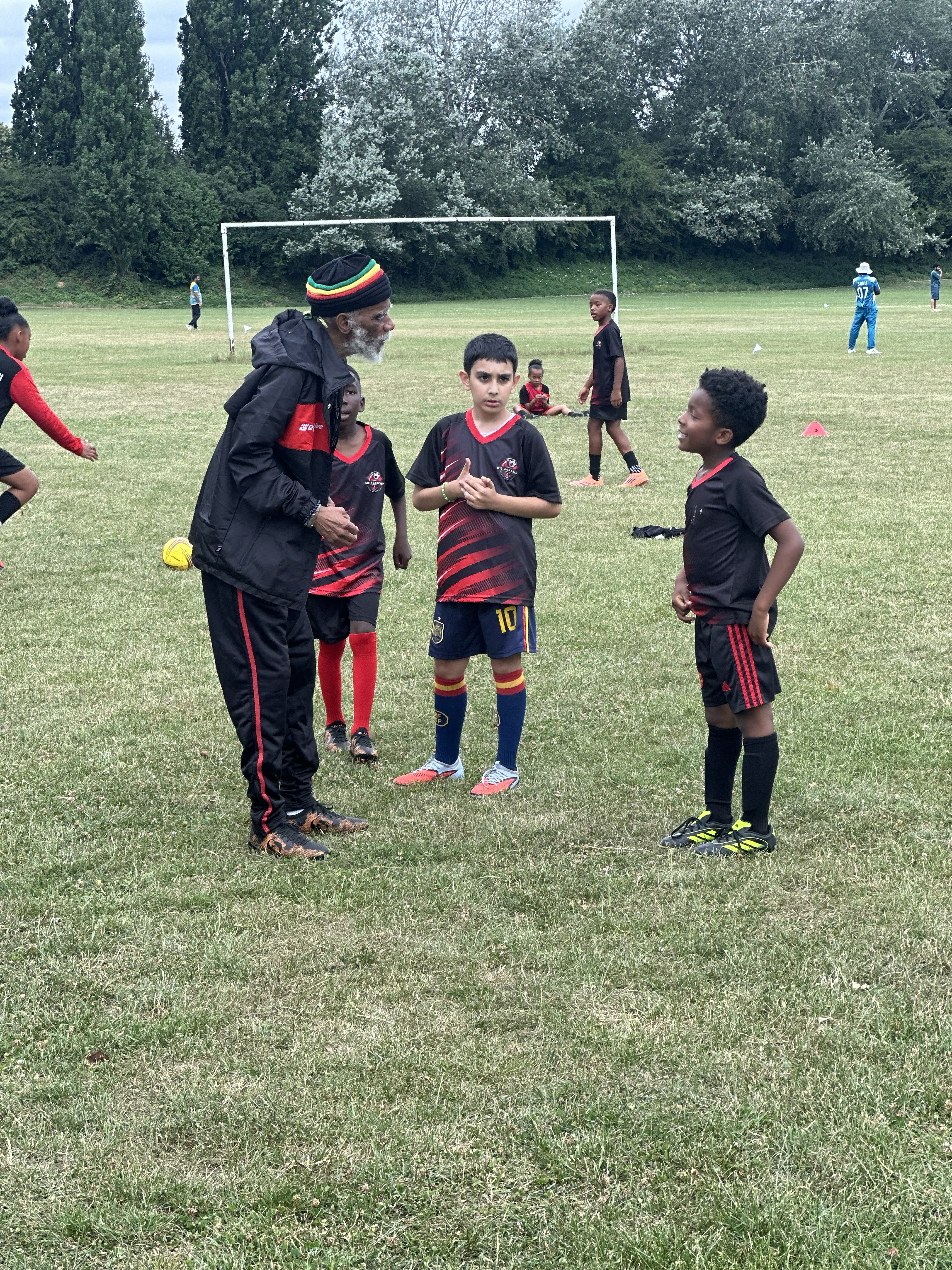 N10 Academy coach chatting with players during a break in training
