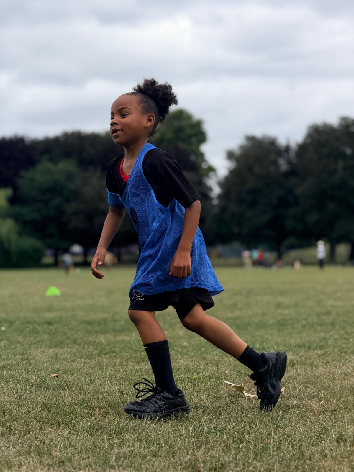 Young N10 Academy player running with the ball during a drill